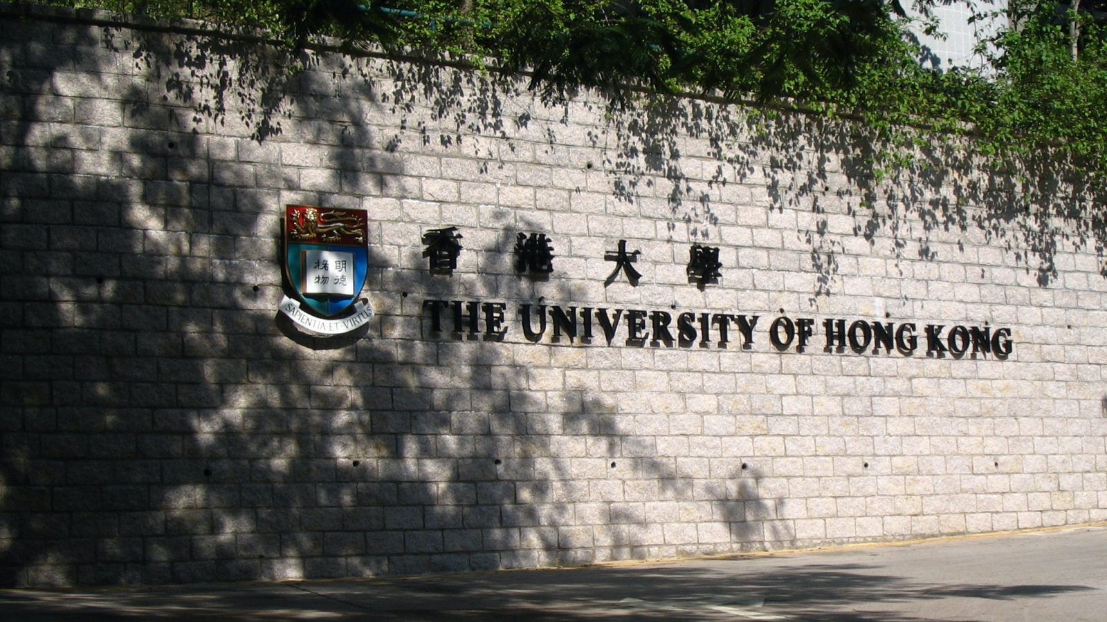 The University of Hong Kong logo is painted on a brick wall.