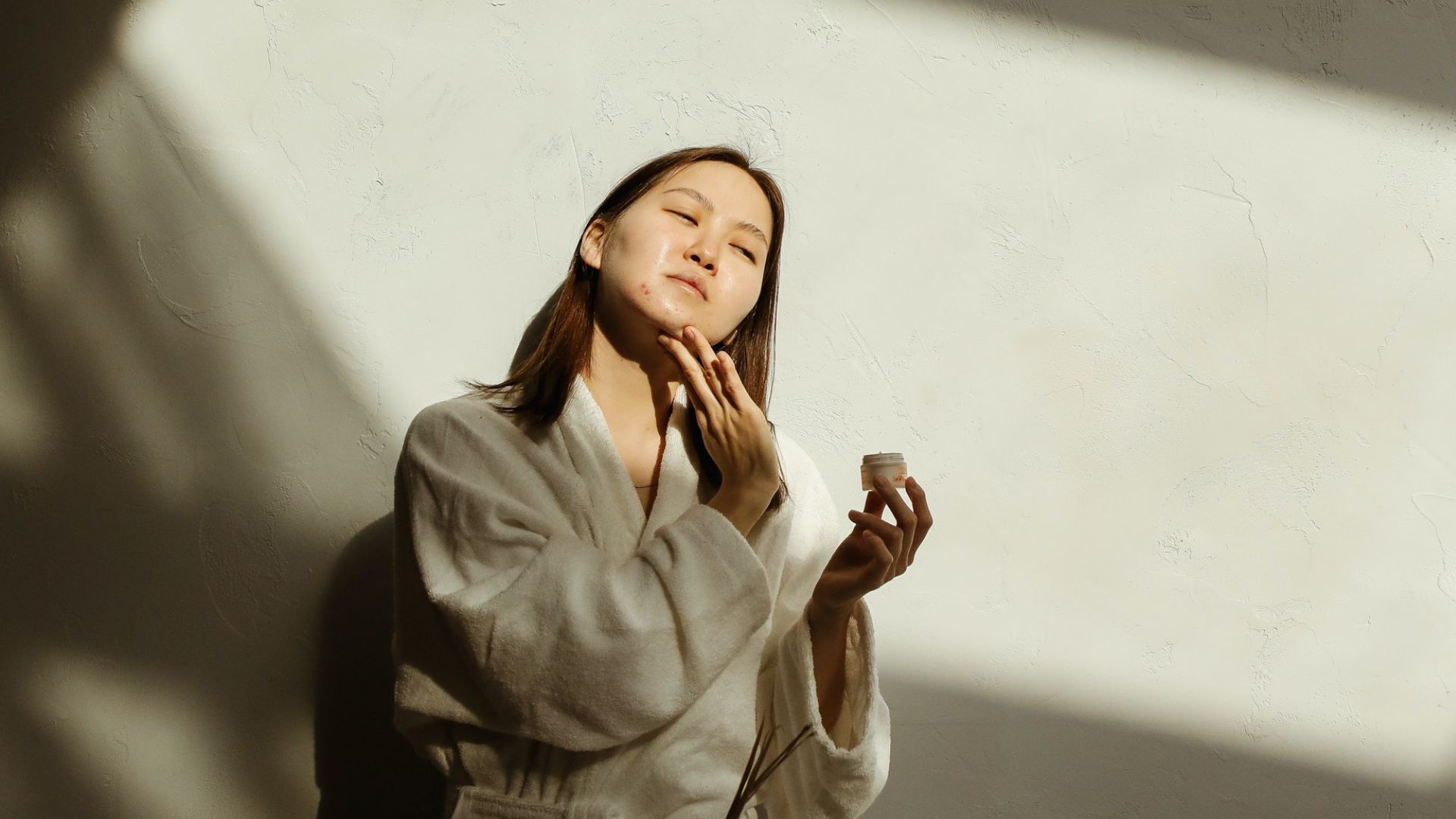 Woman using moisturizer for acne-prone skin
