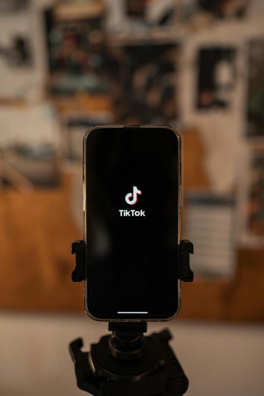 a photo of a phone displaying the tiktok app on a tripod, used in a story on the tiktok ban in america