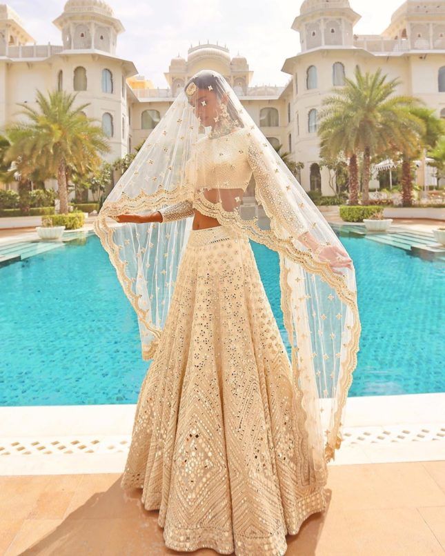 Photo of Pastel pink lehenga with a veil style dupatta and statement bridal  jewellery