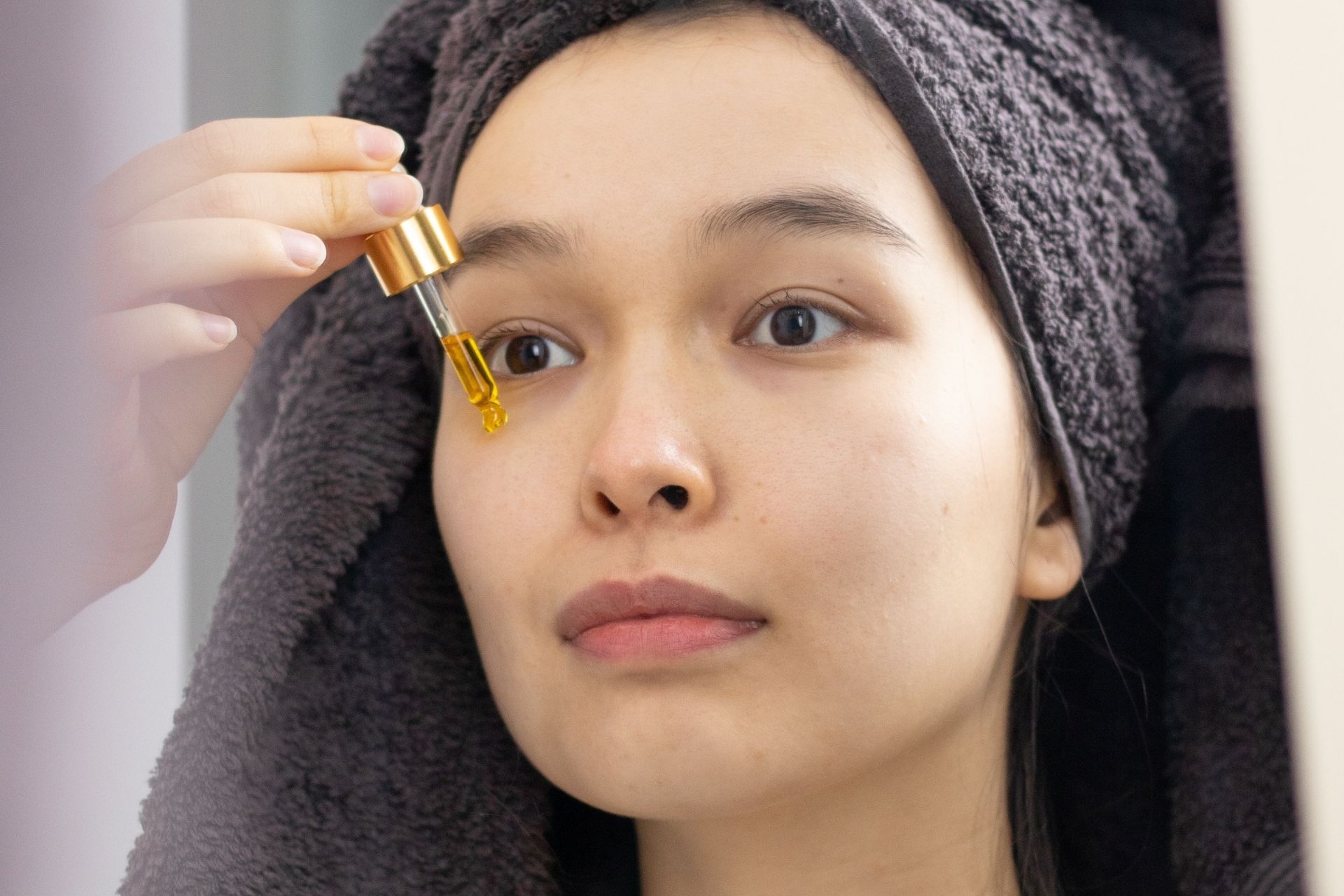 Woman applying grapeseed oil on face